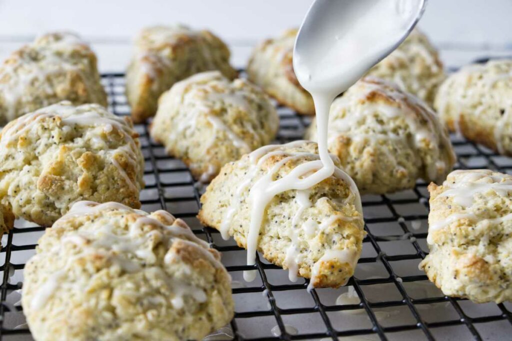 Drizzling lemon glaze over scones.