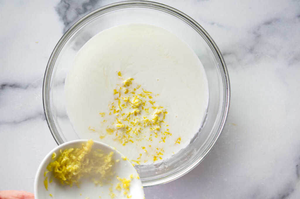 Adding lemon zest to the wet cake batter.